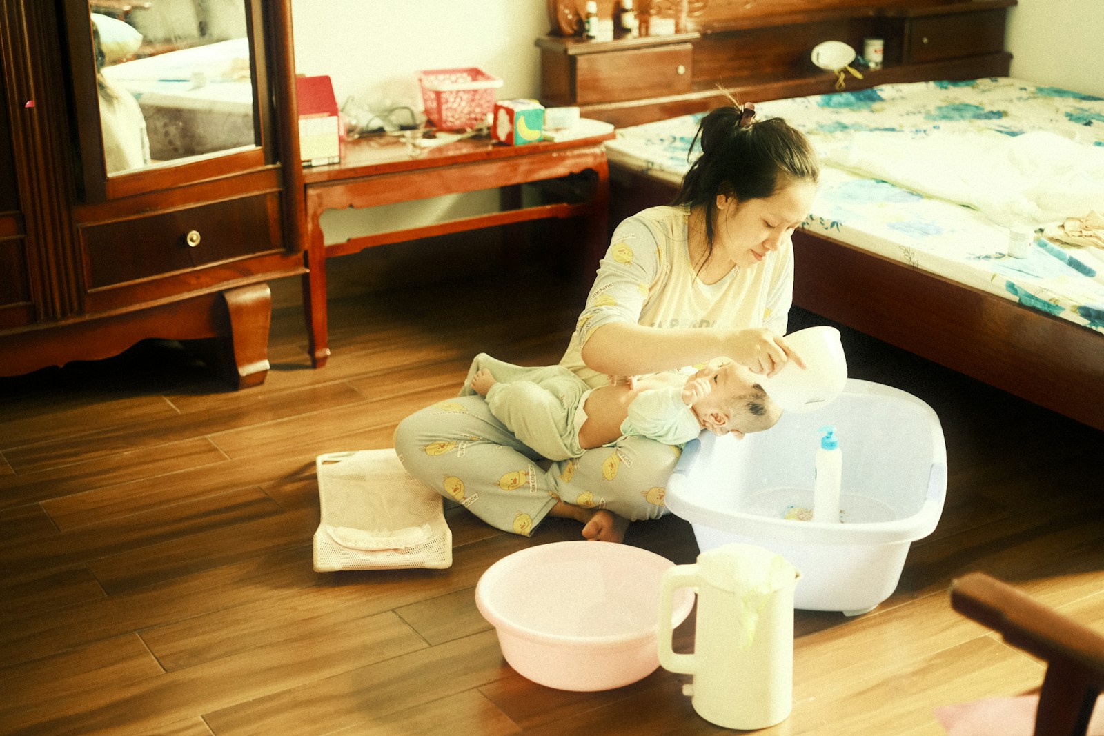 a young girl sitting on the floor playing with a cat