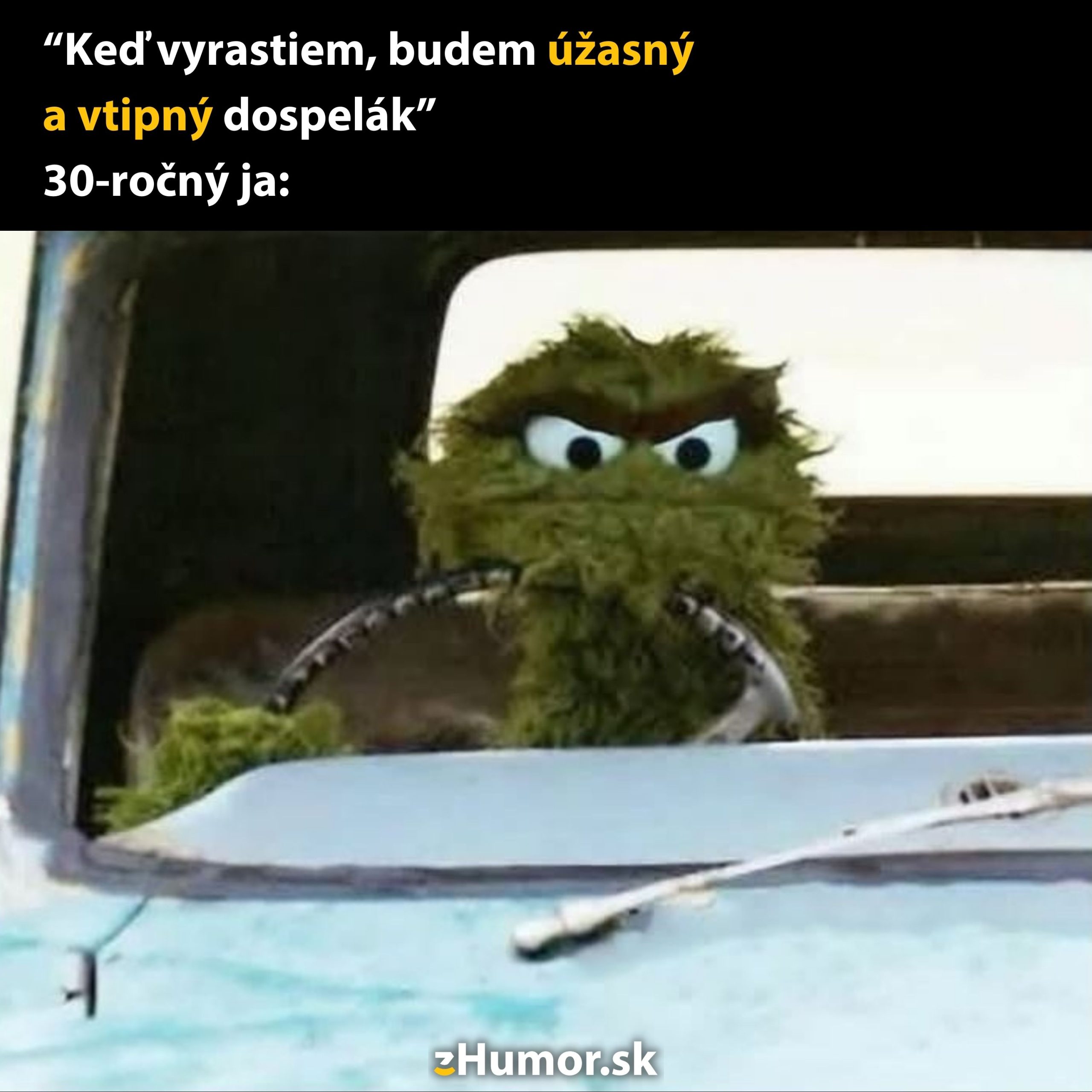 Zelená postavička jazdí na starom aute, vyjadrujúc realitu dospelosti s humorným nadhľadom.