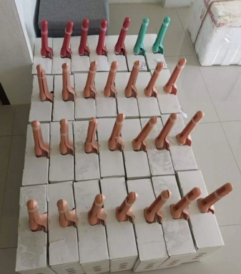 Ručné pumpy rôznej farby umiestnené na kartónových obaloch, zoradené na podlahe.