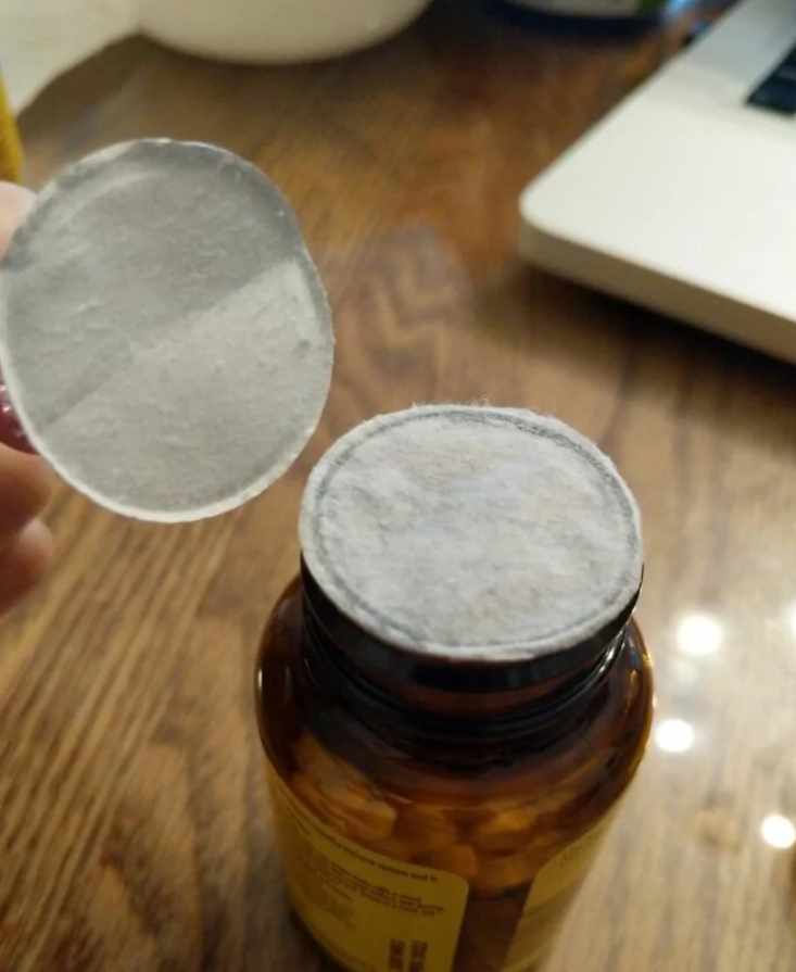 Fóliový uzáver na hnedej fľaške od liekov, dôležitá súčasť pre zachovanie bezpečnosti a čerstvosti obsahu.