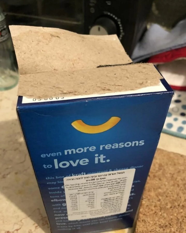 Krabica s makarónmi so syrom s otvoreným vrchnákom, modrým obalom a nálepkou s textom.