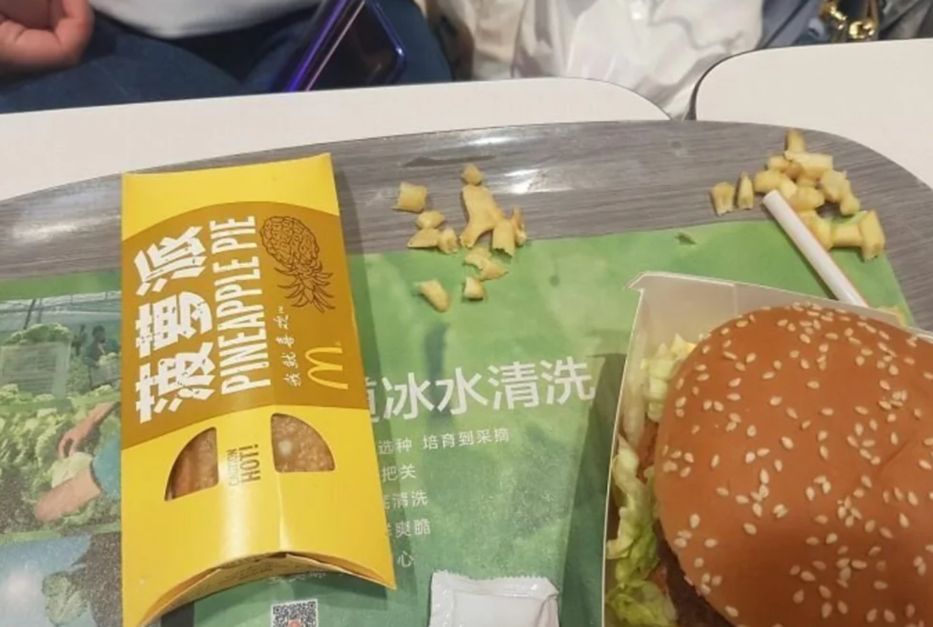 Ananásový koláč a hamburger na tácke v rýchlom občerstvení.