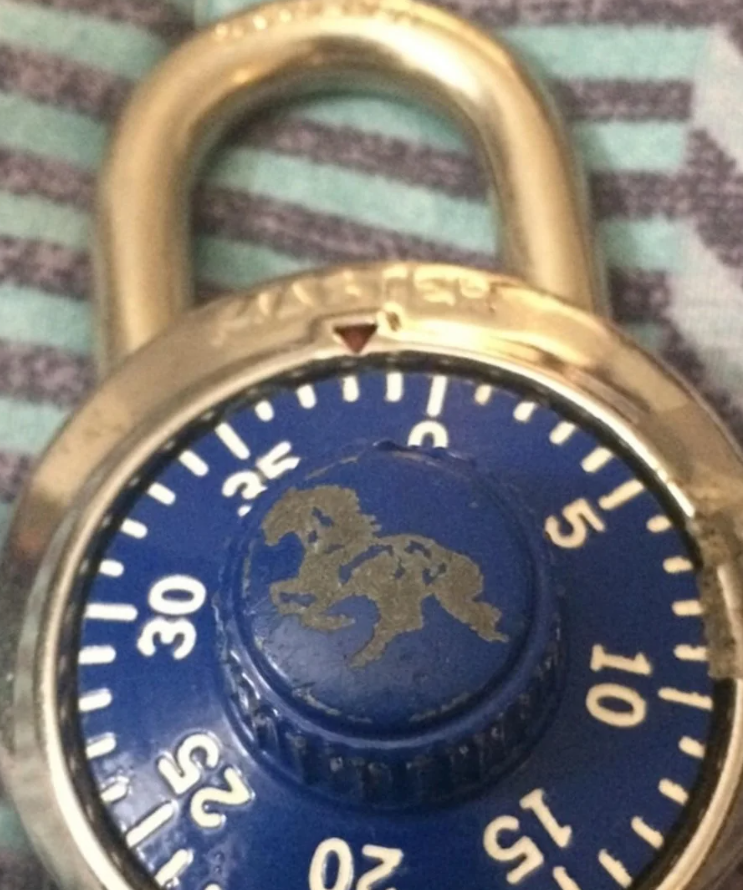 Zámok s modrým číselníkom a vyrytým symbolom koňa, detailný pohľad.