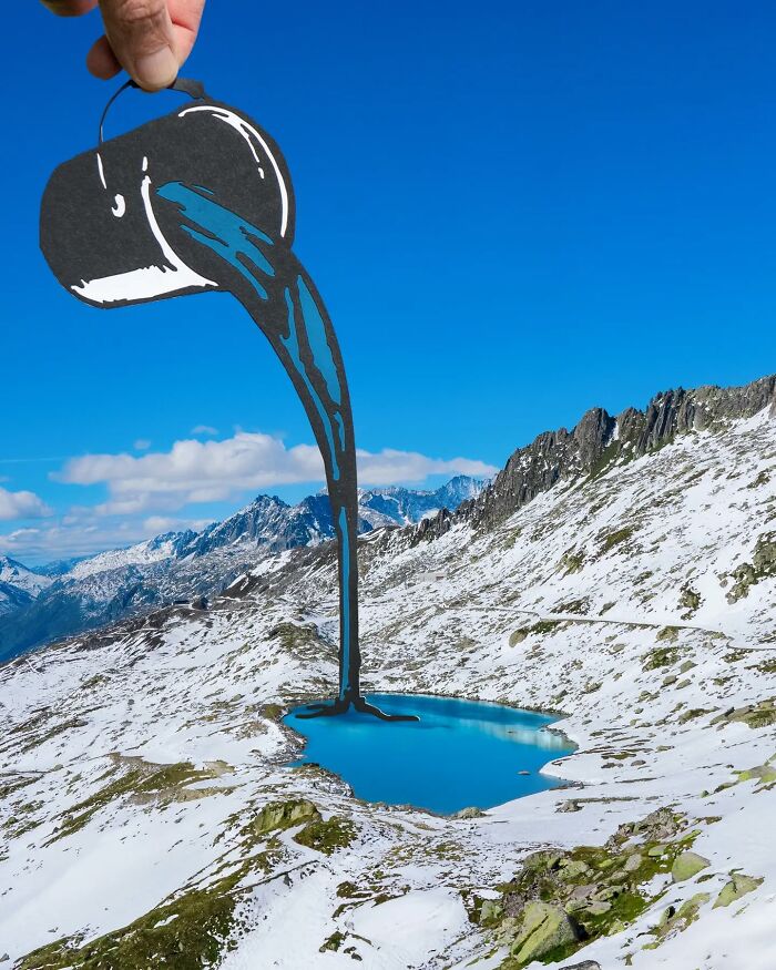 Kreatívna ilúzia s papierovým obrázkom kanvice nad horským jazerom. Snehom pokrytá krajina a jasno modrá obloha.