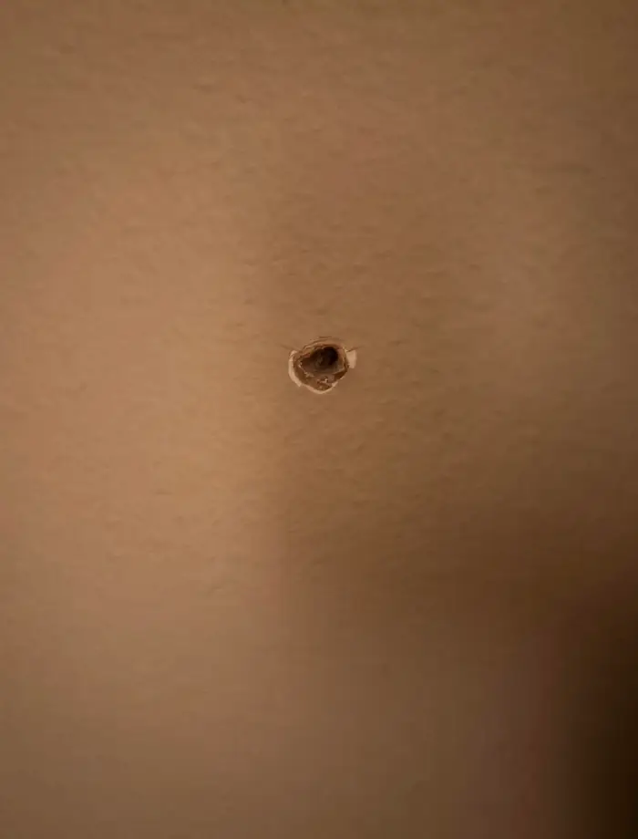 Diera v stene, detail opusteného interiéru, štrbina v omietke.