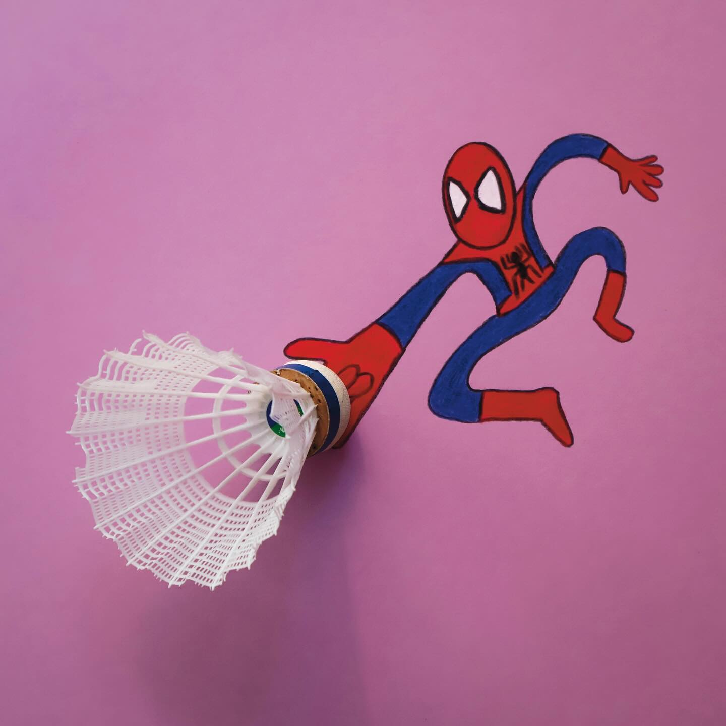 Ilustrácia hrdinu s bedmintonovým košíkom na ružovom pozadí, kreatívne prepojenie športu a komiksu.