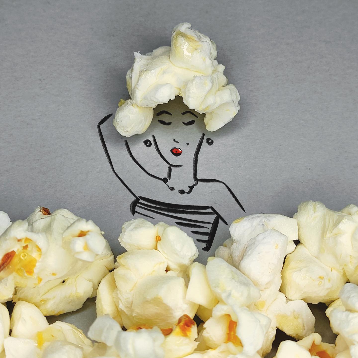 Kresba ženy s popcornovým účesom, kreatívna kombinácia ilustrácie a jedla na šedom pozadí.