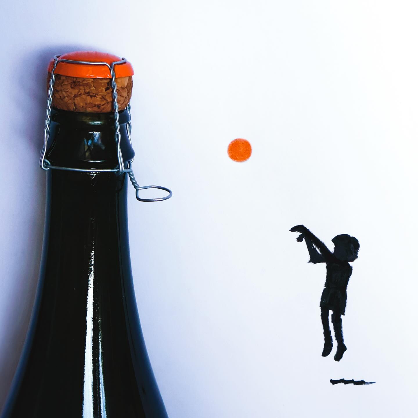 Fľaša so zátkou a kresbou siluety dieťaťa hádžuceho oranžovú loptu na bielom pozadí.