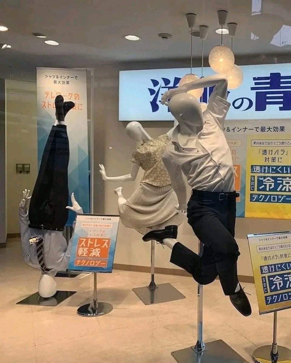 Výklad s figurínami v kreatívnych pózach, jedna stojí dolu hlavou, ďalšie vo vzdušných pohyboch.