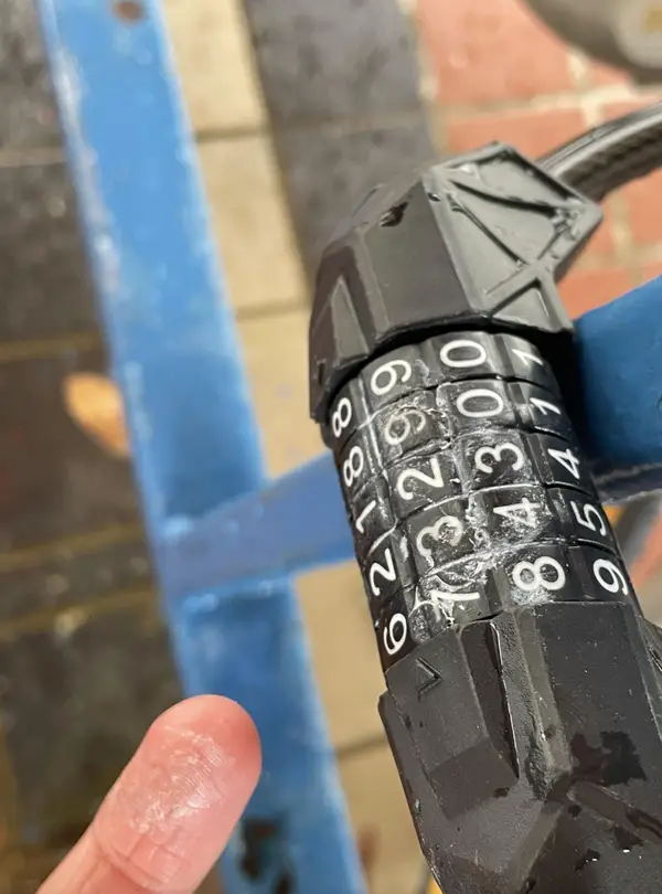 Kombinačný zámok s poškodeným povrchom a odkrytou číselnou kombináciou 81352.