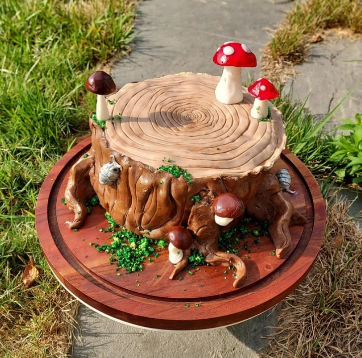 Torta v tvare pňa s jedlými hubami a lesnými detailmi, vhodná na oslavy v prírode alebo lesné tematické párty.