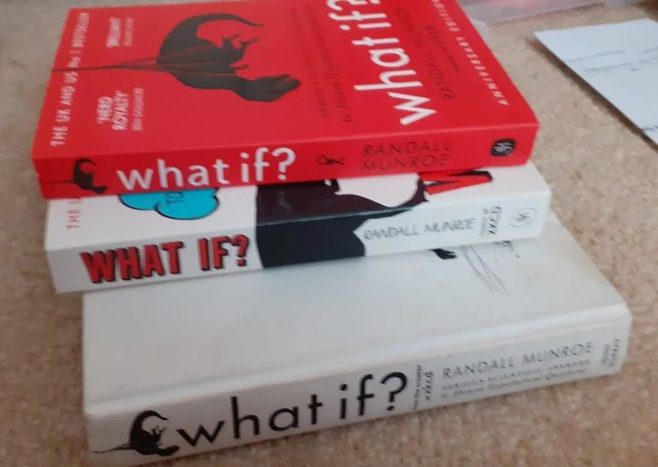 Tri knihy What If? od Randalla Munroeho naukladané na sebe na podlahe.