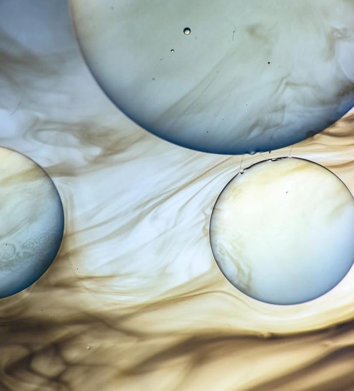 Abstraktné farebné útvary so zamútenými kruhmi a plynulými prechodmi na svetlom pozadí.