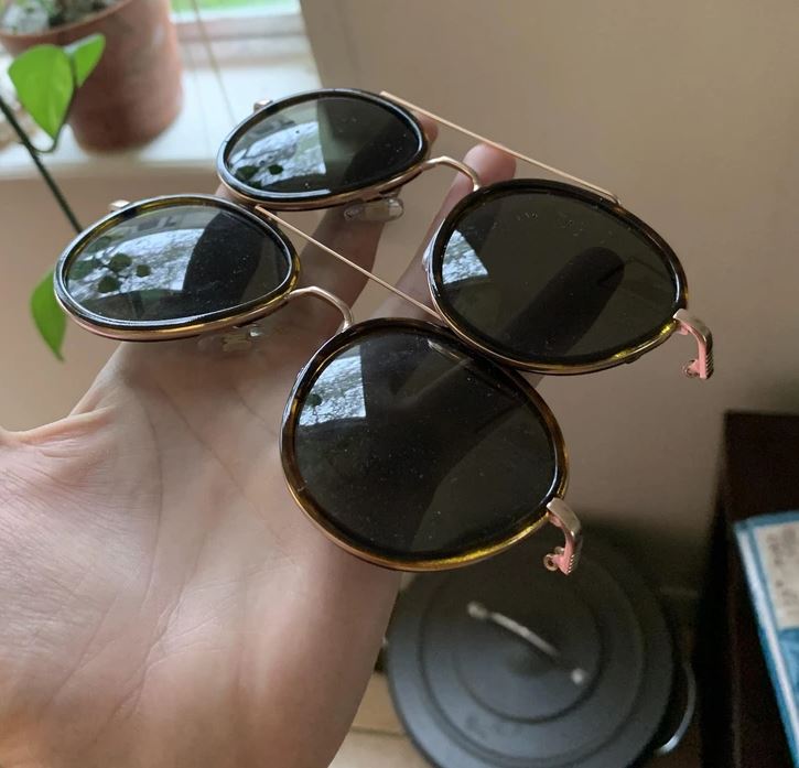 Trojica slnečných okuliarov držiaca v ruke, každý s okrúhlymi čiernymi sklami.