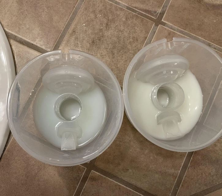 Dva čistiace zásobníky so znečistenou vodou na dlaždicovom povrchu kúpeľne.