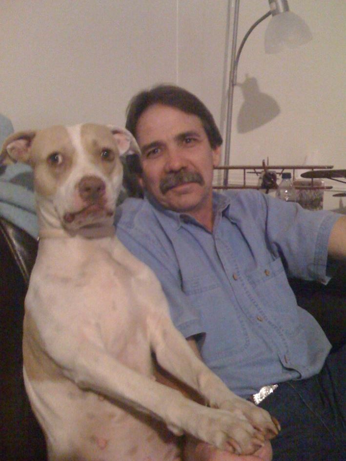 Muž a pes sediaci na pohovke v obývačke, blízka a pokojnú atmosféra domova.