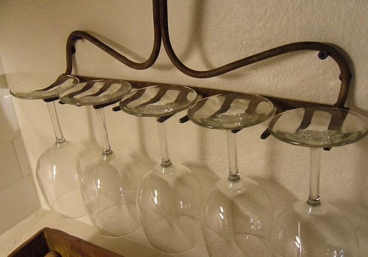 Závesný držiak na päť pohárov na víno na stene, pripravený na štýlové servírovanie nápojov.