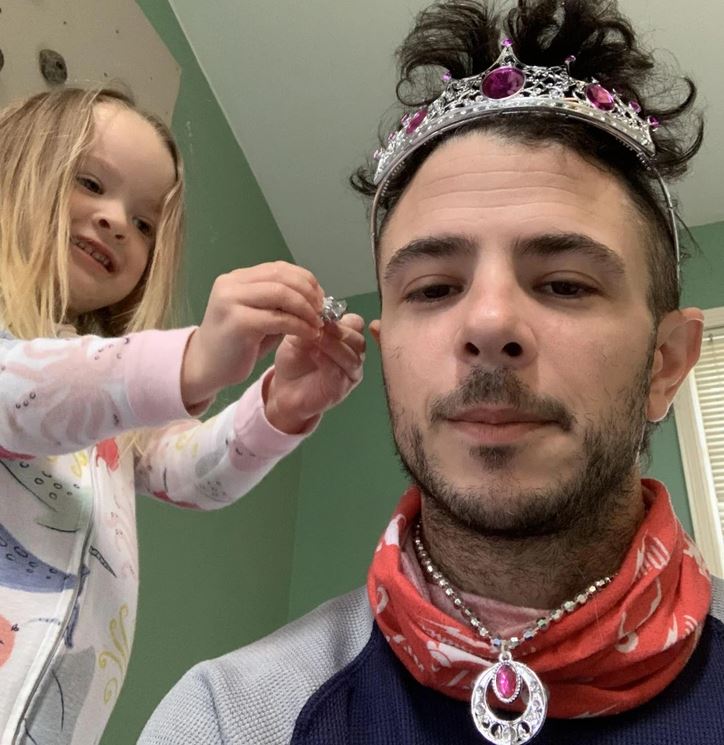 Dievčatko zdobí muža korunkou a šperkami, hranie na princeznú.