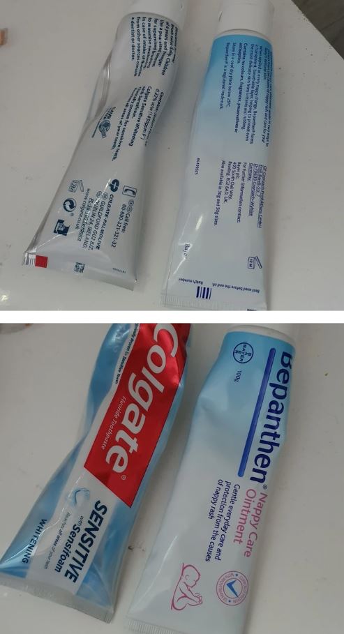 Dentálna pasta a detský krém na starostlivosť vedľa seba na bielom povrchu.