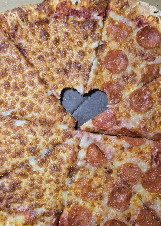 Pizza so srdcovým vyrezom v strede, kombinácia syra a salámy na tenkej kôrke.