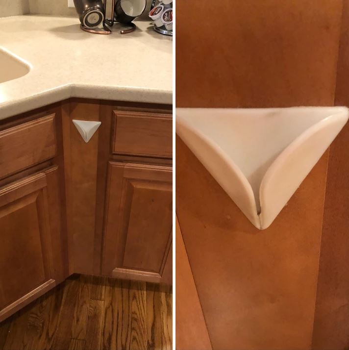 Biely plastový chránič rohovej skrinky v kuchyni na drevenej skrinkovej doske.