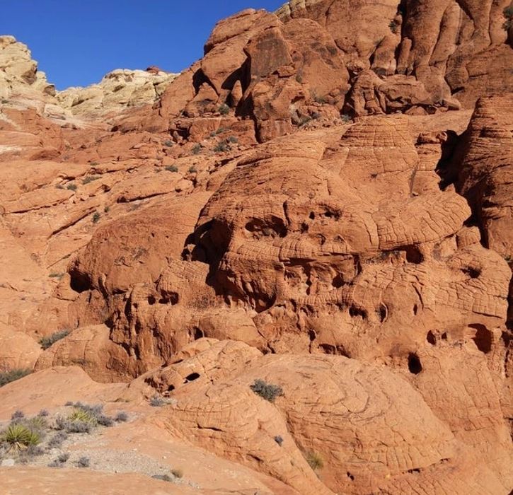 Červené skalné útvary v púšti pod modrou oblohou, prírodná kamenná krajina s nádherným reliéfom.