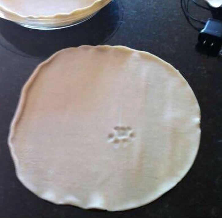 Obrázok cesta s odtlačkom labky, pripravené na pečenie na kuchynskej doske.