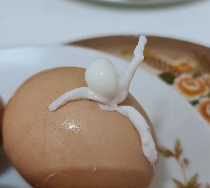 Varené vajíčko na tanieri s nezvyčajnou bielkovou štruktúrou na vrchu.