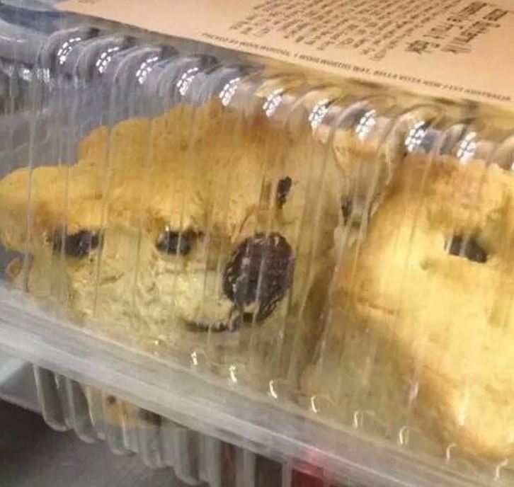 Balené pečivo pripomínajúce tvár so škvrnami, pod priehľadným plastovým krytom.