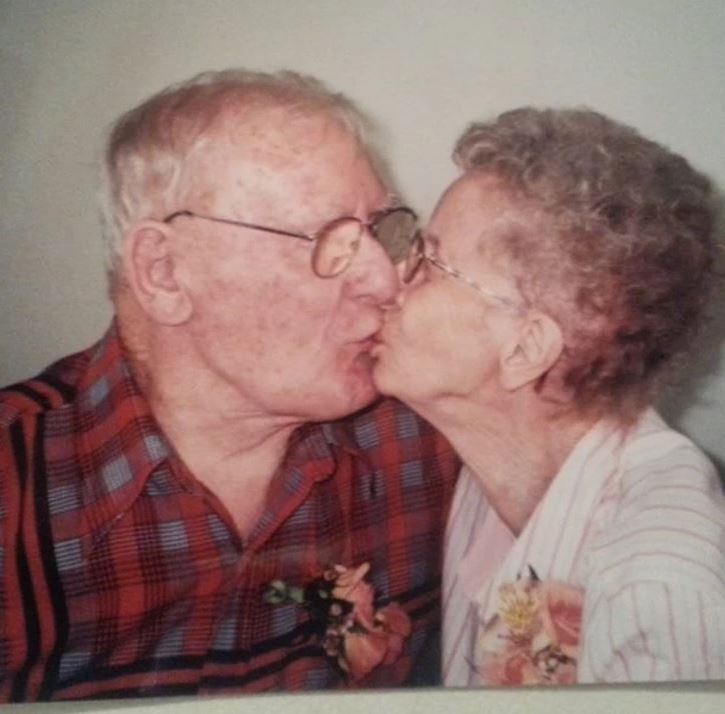 Starší pár sa nežne bozkáva a prejavuje si lásku.