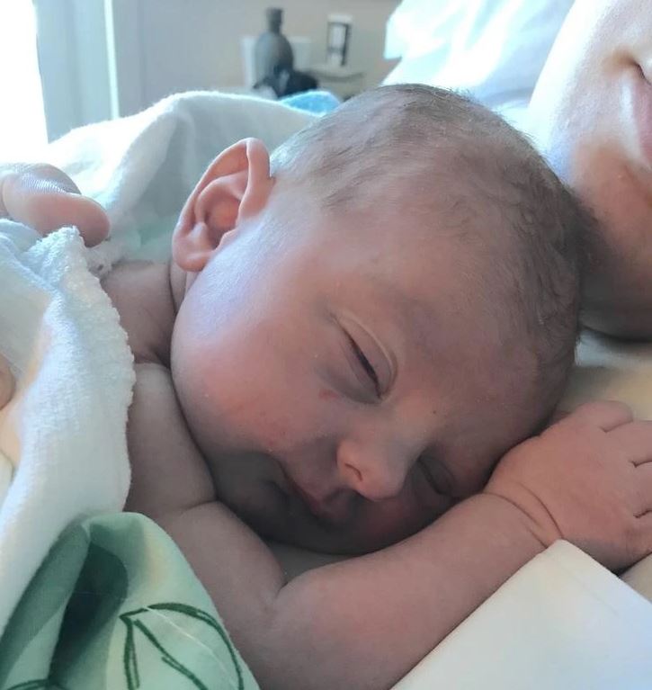 Novorodenec spokojne spí na maminej hrudi, zabalený v mäkkej deke, v pokojnej a láskyplnej atmosfére.