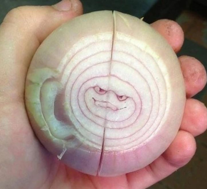 Cibuľa so zábavným vzorom tváre vo vnútri, ktorá vyzerá ako úsmev.