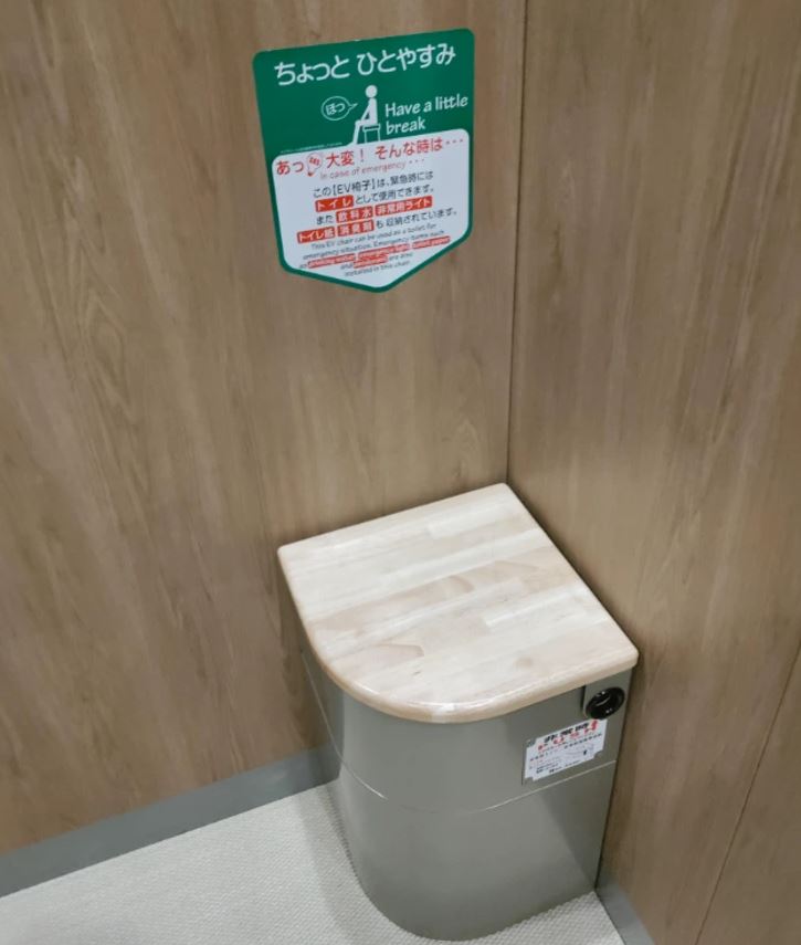 Stolička na oddych v rohu miestnosti s japonskými inštrukciami na stene.