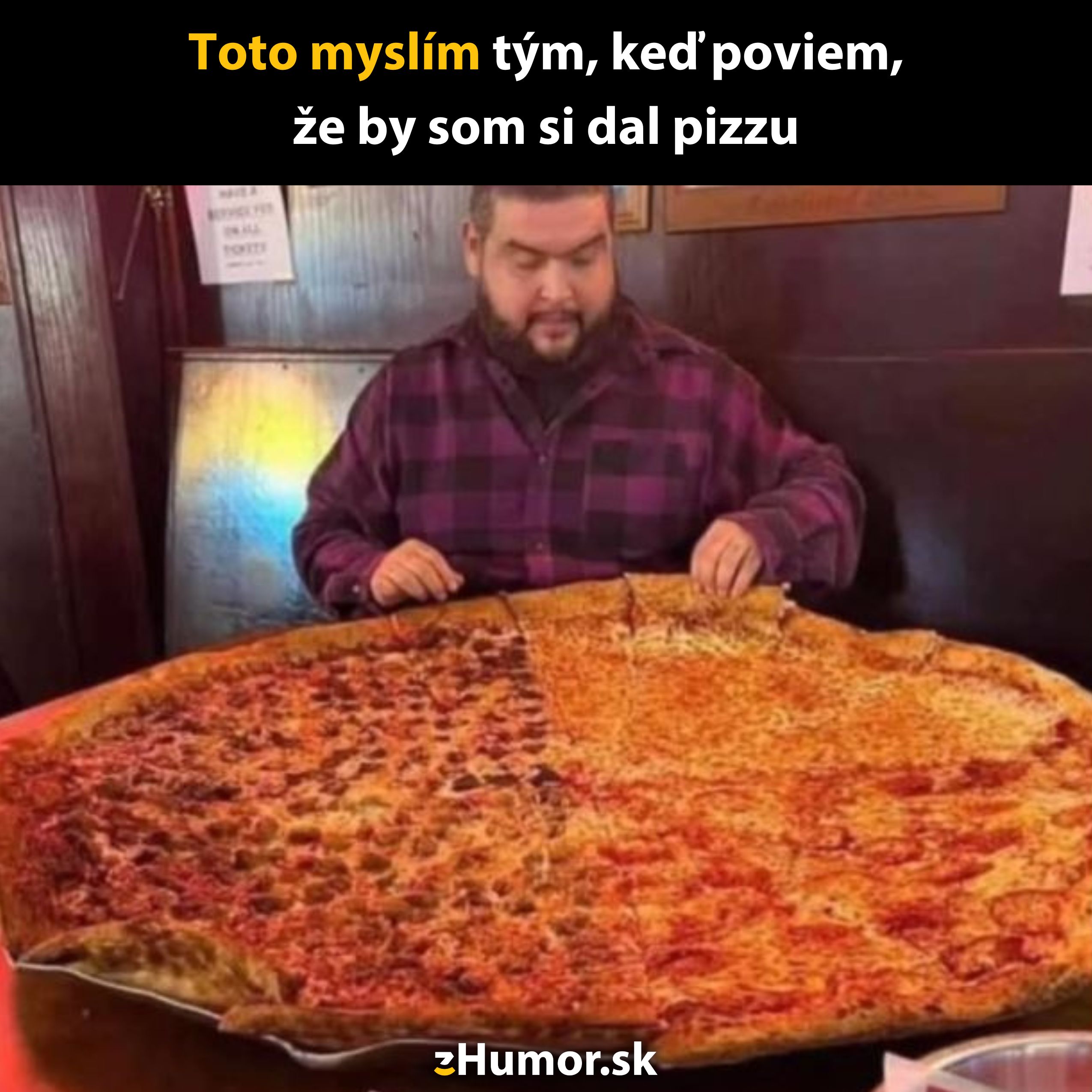 Muž v burgundy košeli sedí pred obrovskou pizzou v reštaurácii, s nápisom o túžbe po pizzi.