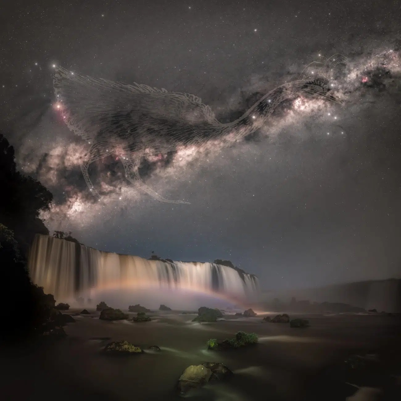 Vodopády pod hviezdnou oblohou s jemnou dúhou a nočnými hviezdami v pozadí, vytvárajúce magickú scénu.