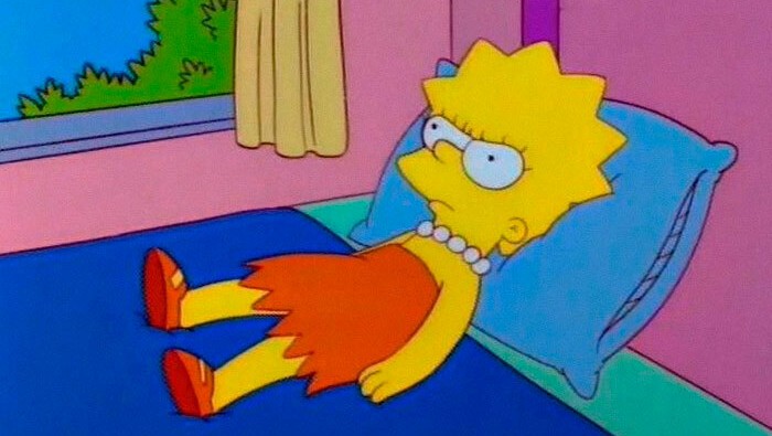 Animovaná postava s výrazom zamyslenia, leží na posteli v slnečnej miestnosti, oblečená v oranžovo-červenom šate.