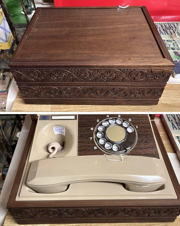 Dekoratívna drevená krabica, ktorá po otvorení odhalí retro telefón s otočným číselníkom.