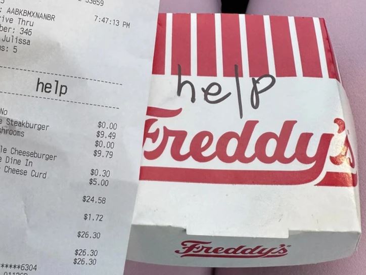 Účtenka z fast foodu Freddy's a krabička s nápisom help na vrchu.