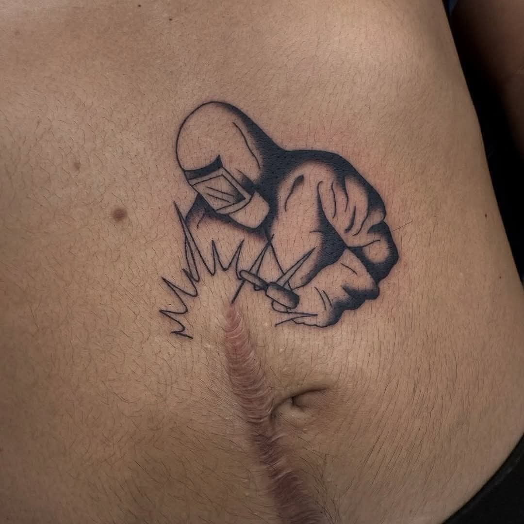 Tetovanie zvárača na bruchu so zjazvenou pokožkou, symbolika remeselnej práce a odvahy.