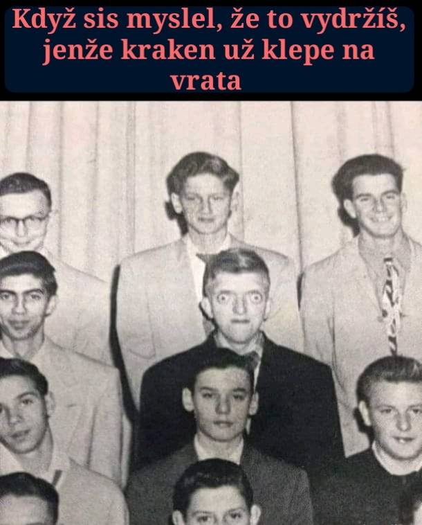 Skupinová fotka mužov v oblekoch s vtipným textom nad hlavami, vystrašene vyzerajúci mladík v strede.