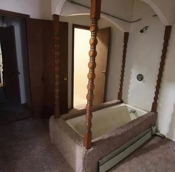 Kúpeľňa s vintage vaňou ozdobenou drevenými stĺpmi v rustikálnom štýle.