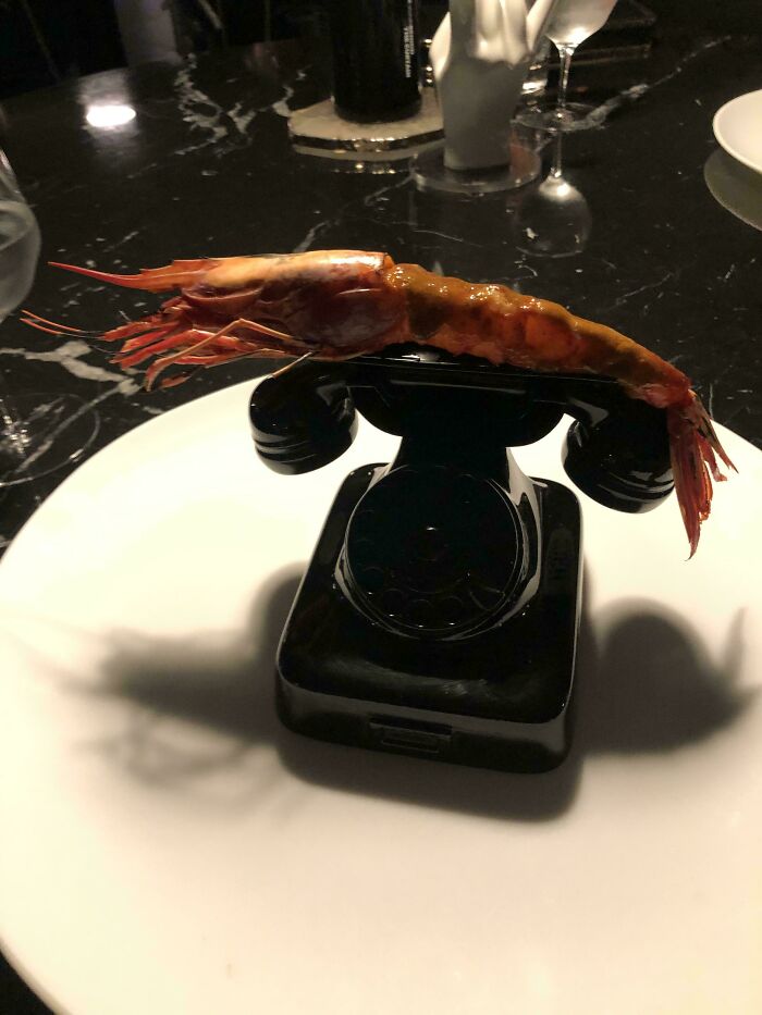 Kreveta servírovaná na retro telefóne ako kreatívna reštauračná prezentácia jedla.