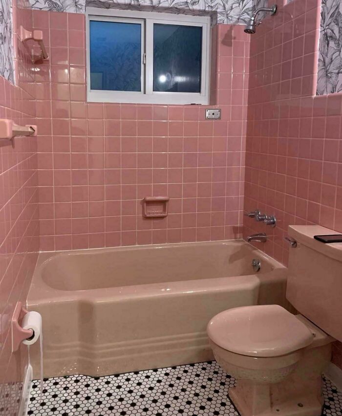 Ružová retro kúpeľňa s vaňou, toaletou a čierno-bielou podlahou. Vintage dizajn pre milovníkov starého štýlu.