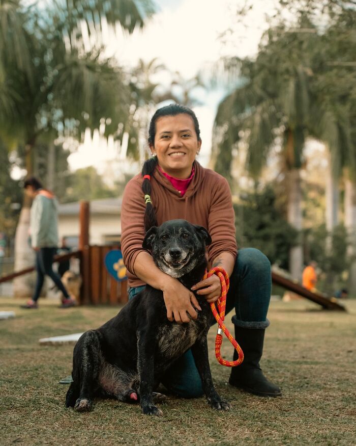 Ľudia v parku pózujú so svojim psom počas príjemného popoludnia na čerstvom vzduchu.