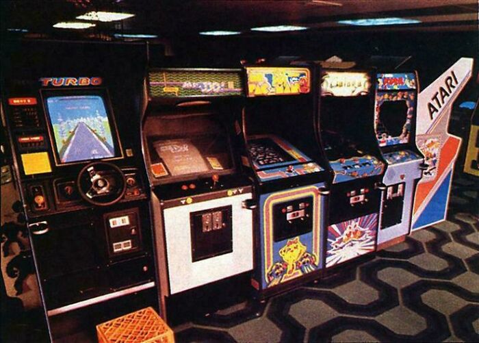 Retro arkádové automaty v herni, vrátane hier ako Turbo a ďalších známych titulov.