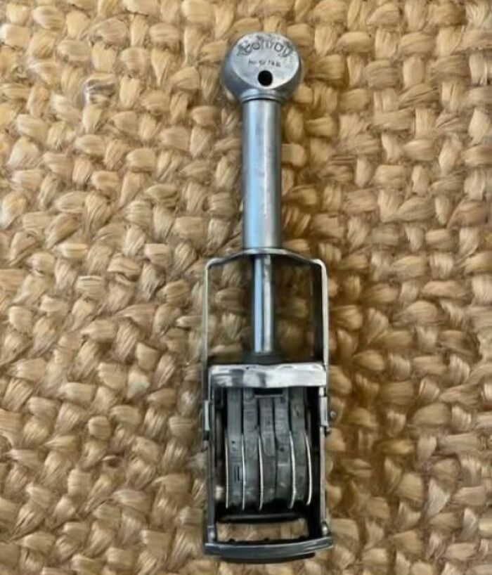 Starý kovový dátumový razítko na jutovom povrchu.