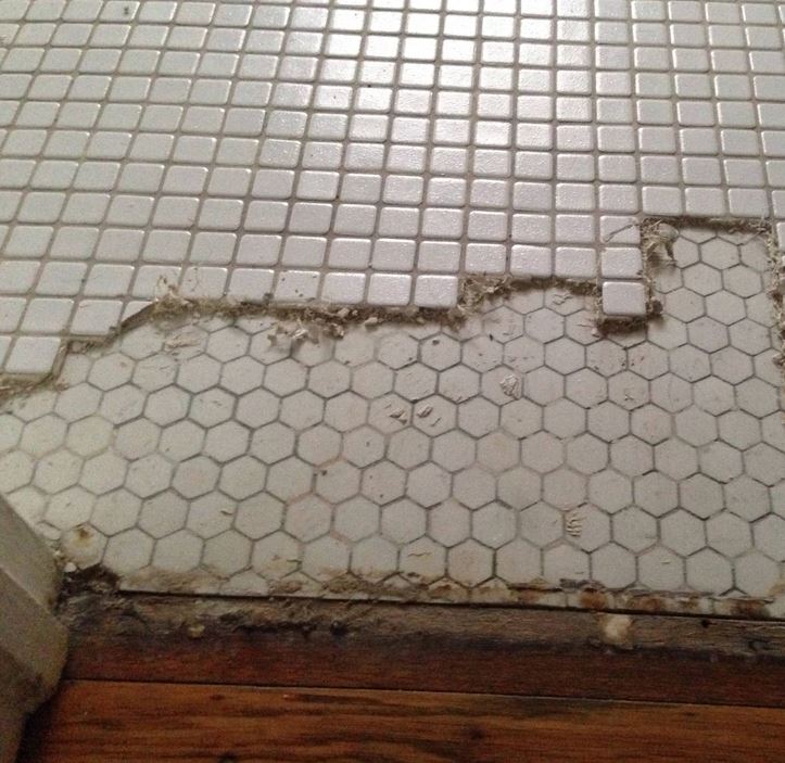 Podlaha s poškodenými dlaždicami: prechod medzi štvorcovými a šesťuholníkovými vzormi, potreba opravy.