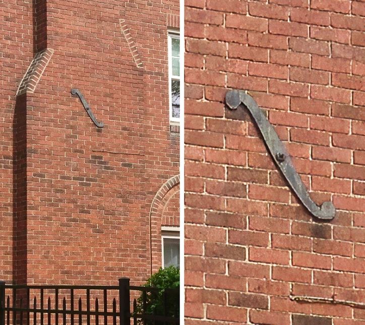 Tehlová stena s kovovou výstužou v tvare šípu, detailný pohľad na konštrukciu fasády.