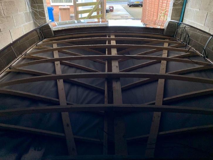 Strešná konštrukcia dvojgaráže s drevenými nosníkmi a pohľadom na okolitú ulicu.