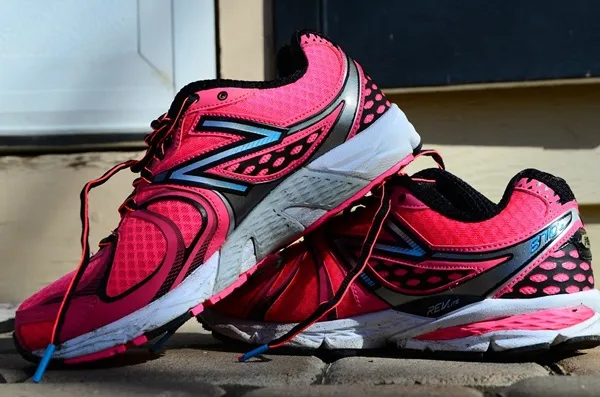 Ružové športové tenisky s čiernymi detailmi, ideálne na behanie a voľnočasové aktivity.